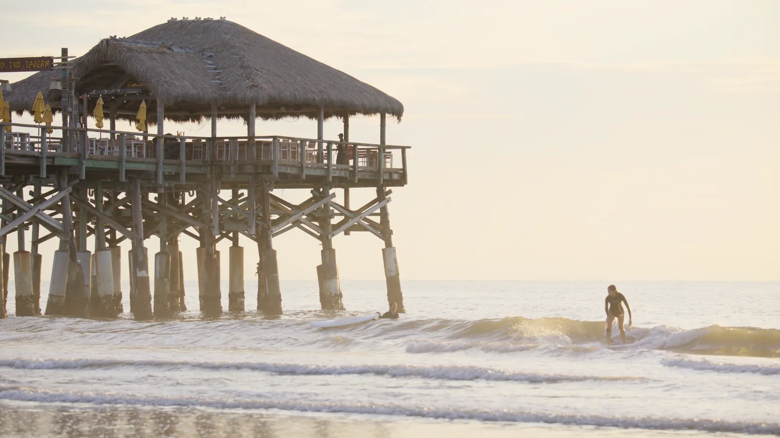 The pier at sunrise through PursuitLuts, the sky holding its gradient and cloud.